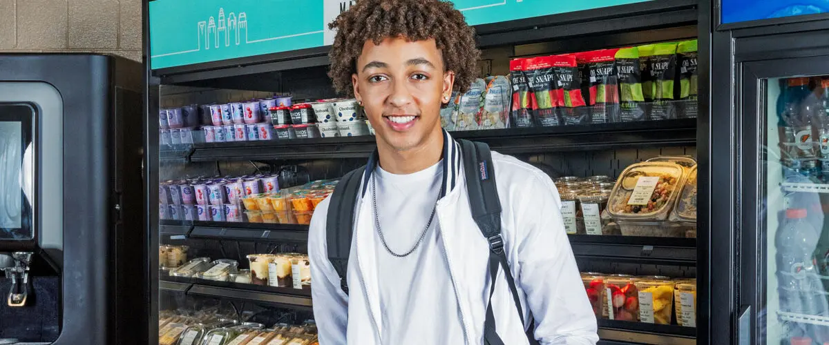 Student smiling in middle of c-store